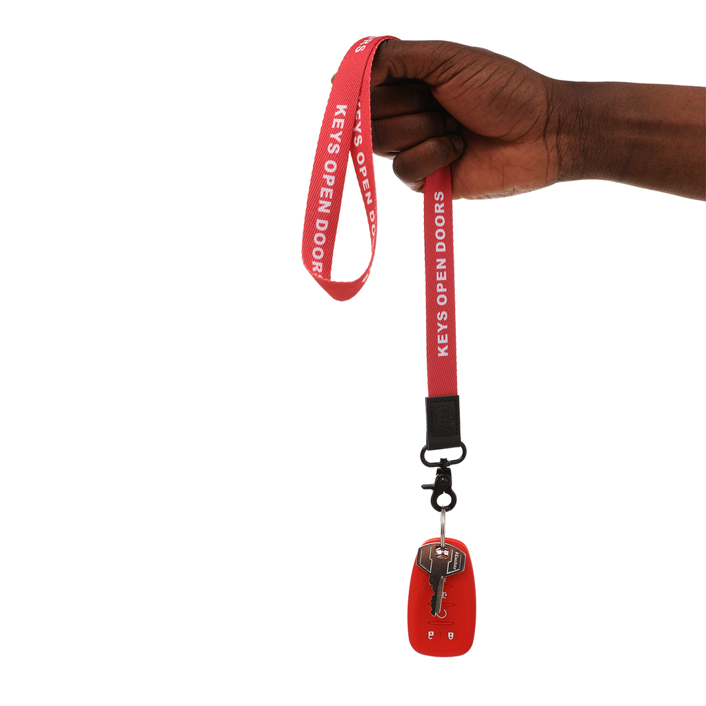 Red lanyard with keychain held by a hand on a white background