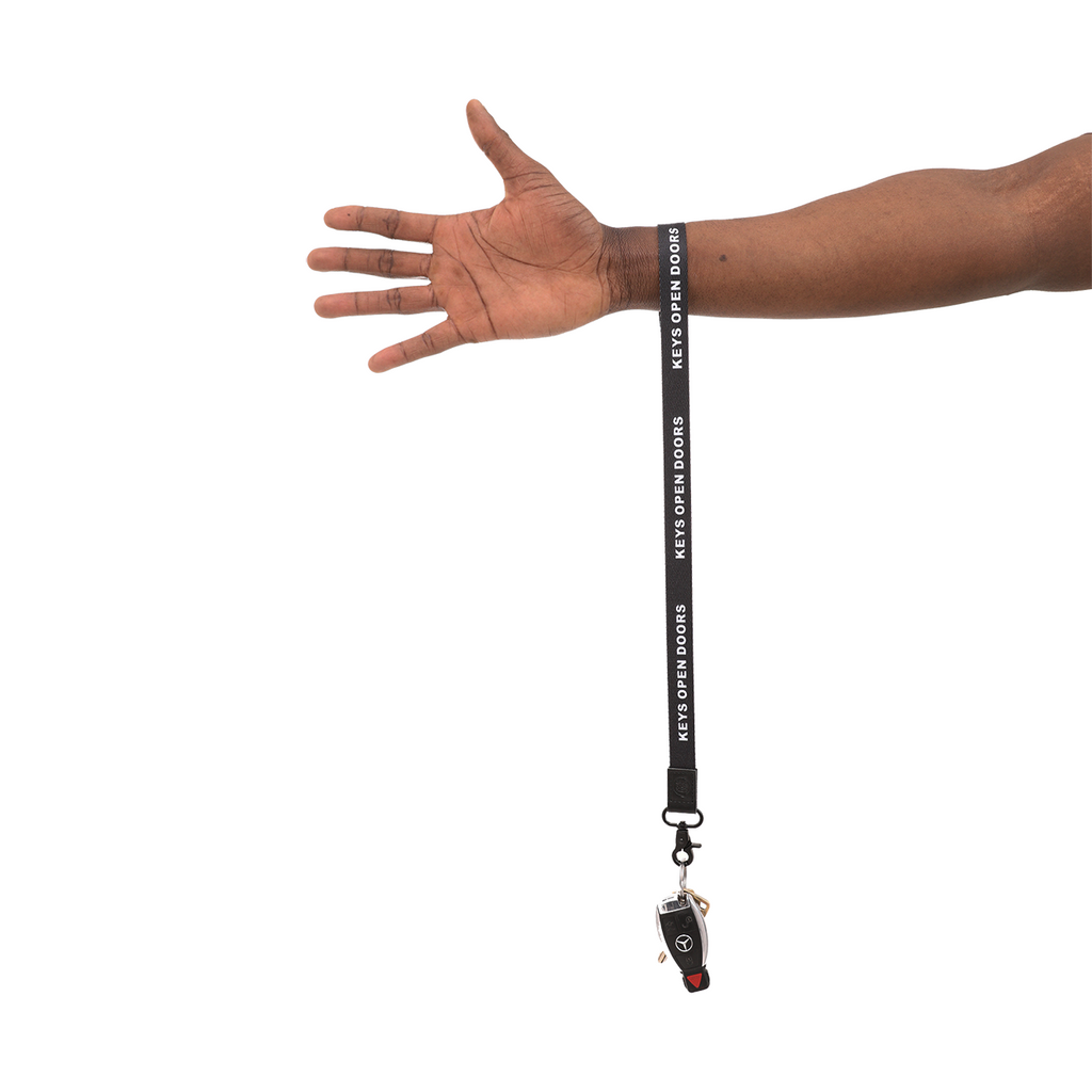 Black lanyard with a keychain attached to a person's wrist on a white background