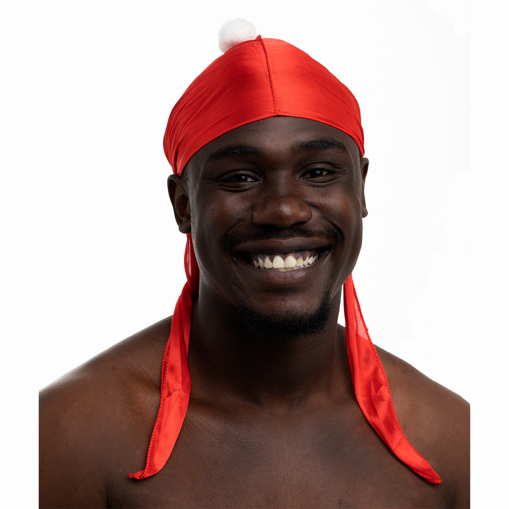 Man wearing a red Santa Durag with a white pom-pom on a white background